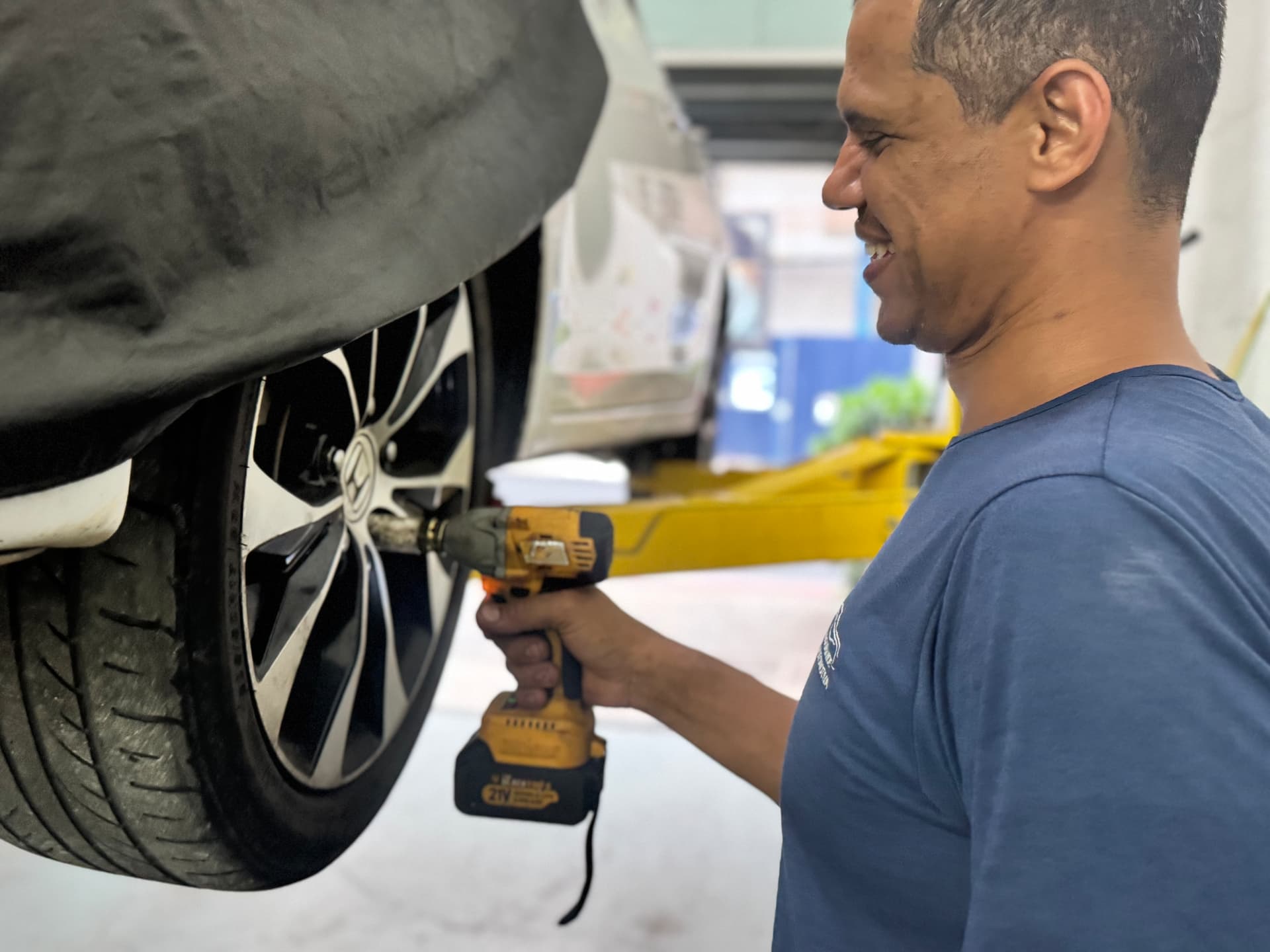 Mecânico trabalhando na roda de um veículo na Oficina do Grande